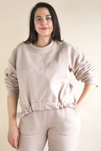 Load image into Gallery viewer, Woman wearing a beige sweatshirt and pants against a plain background