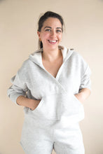 Load image into Gallery viewer, Woman wearing a light gray hoodie against a beige background