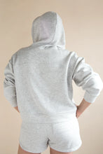 Load image into Gallery viewer, Person wearing a gray hoodie and shorts set on a beige background