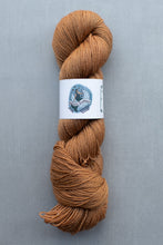 Load image into Gallery viewer, Brown skein of yarn with a label on a gray background