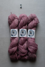 Load image into Gallery viewer, Three skeins of fuzzy pinkish-purple yarn with white paper 