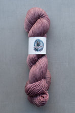 Load image into Gallery viewer, Pink skein of yarn with a label on a gray background
