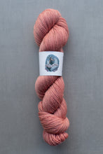 Load image into Gallery viewer, Pink skein of yarn with a label on a gray background