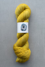 Load image into Gallery viewer, Yellow skein of yarn with a label on a gray background