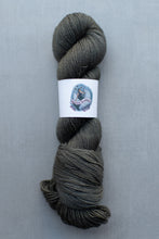 Load image into Gallery viewer, Gray skein of yarn with a label on a gray background