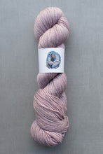 Load image into Gallery viewer, Pink skein of yarn with a label on a gray background