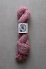 Load image into Gallery viewer, Pink skein of yarn with a label on a gray background