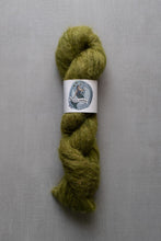 Load image into Gallery viewer, Green skein of yarn with a label on a gray background