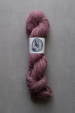 Load image into Gallery viewer, Mauve skein of yarn with a label on a gray background