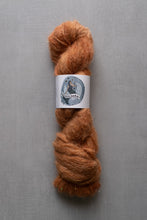 Load image into Gallery viewer, Brown skein of yarn with a label on a gray background