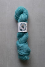 Load image into Gallery viewer, Turquoise skein of yarn with a label on a gray background
