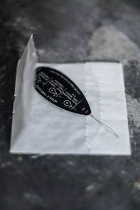 Black and white label on a white square with a dark textured background
