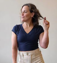 Load image into Gallery viewer, Woman wearing a navy blue top and beige pants against a plain background