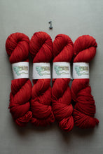 Load image into Gallery viewer, Four skeins of bright red yarn arranged side by side on a light gray background, with a small number 1 printed above them. Each skein has a white paper label wrapped around it.