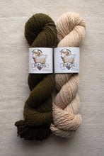Load image into Gallery viewer, Two skeins of yarn, one green and one beige, with labels on a light gray background.