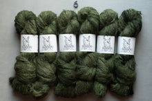 Load image into Gallery viewer, Six skeins of chunky olive green yarn arranged in two rows on a light gray background, each wrapped with a white paper band featuring a dog illustration and the text 'CANVAS'.