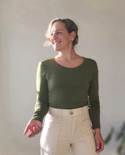 Load image into Gallery viewer, Person wearing a green long-sleeve top and beige pants against a plain background