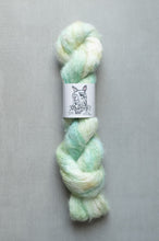 Load image into Gallery viewer, Braided skein of yarn with a label on a gray background