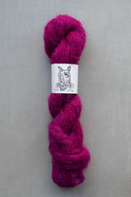 Load image into Gallery viewer, Fuchsia skein of yarn with a label on a gray background