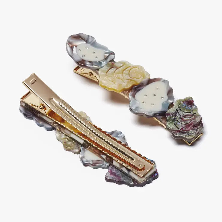 Decorative hair clips with multicolored stones on a white background