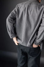 Load image into Gallery viewer, Person wearing a gray shirt and dark pants against a dark background