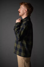 Load image into Gallery viewer, Man wearing a green plaid shirt against a gray background