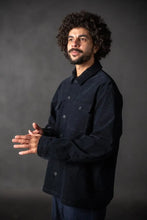 Load image into Gallery viewer, Man wearing a black jacket against a dark background