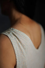 Load image into Gallery viewer, Close-up of a person wearing a sleeveless checkered top with a blurred background