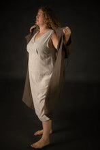 Load image into Gallery viewer, Person wearing a beige dress and coat against a dark background