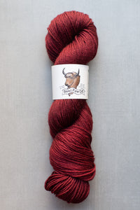 Red skein of yarn with a label on a gray background