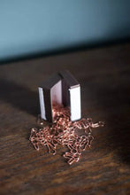 Load image into Gallery viewer, Metallic object with a chain on a wooden surface