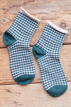 Load image into Gallery viewer, Pair of green and white checkered socks on a wooden surface