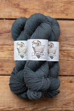 Load image into Gallery viewer, Two skeins of dark gray yarn with 'Pishful' labels on a wooden surface