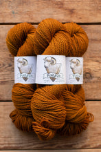 Load image into Gallery viewer, Three skeins of orange yarn with labels on a wooden surface