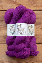 Load image into Gallery viewer, Three skeins of purple yarn with 'Pishkun' labels on a wooden background