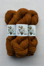 Load image into Gallery viewer, Three skeins of Pishkun wool yarn in a warm rust-brown color, arranged side-by-side on a light gray textured background.