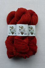 Load image into Gallery viewer, Three skeins of dark red yarn with white paper labels wrapped around them, photographed on a light gray textured background. The labels show the brand name Pishkun.