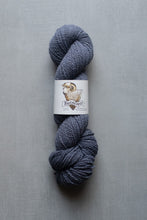 Load image into Gallery viewer, Blue skein of yarn with a label on a gray background