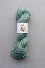 Load image into Gallery viewer, Green skein of yarn with a label on a gray background