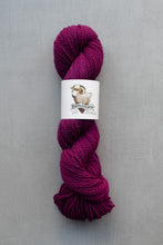Load image into Gallery viewer, Purple skein of yarn with a label on a gray background