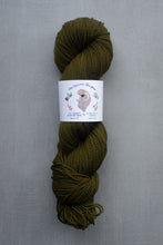 Load image into Gallery viewer, Olive green skein of yarn with a label on a gray background