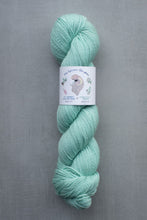 Load image into Gallery viewer, Mint green skein of yarn with a label on a gray background
