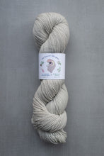 Load image into Gallery viewer, Gray skein of yarn with a label on a gray background