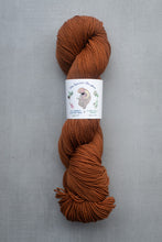 Load image into Gallery viewer, Brown skein of yarn with a label on a gray background
