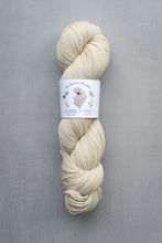 Load image into Gallery viewer, Cream-colored skein of yarn with a label on a gray background