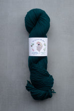 Load image into Gallery viewer, Teal skein of yarn with a label on a gray background