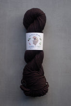 Load image into Gallery viewer, Brown skein of yarn with a label on a gray background