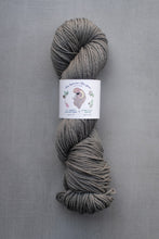 Load image into Gallery viewer, Gray skein of yarn with a label on a gray background