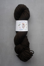 Load image into Gallery viewer, Brown skein of yarn with a label on a gray background