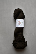 Load image into Gallery viewer, Dark brown skein of yarn with a label on a gray background